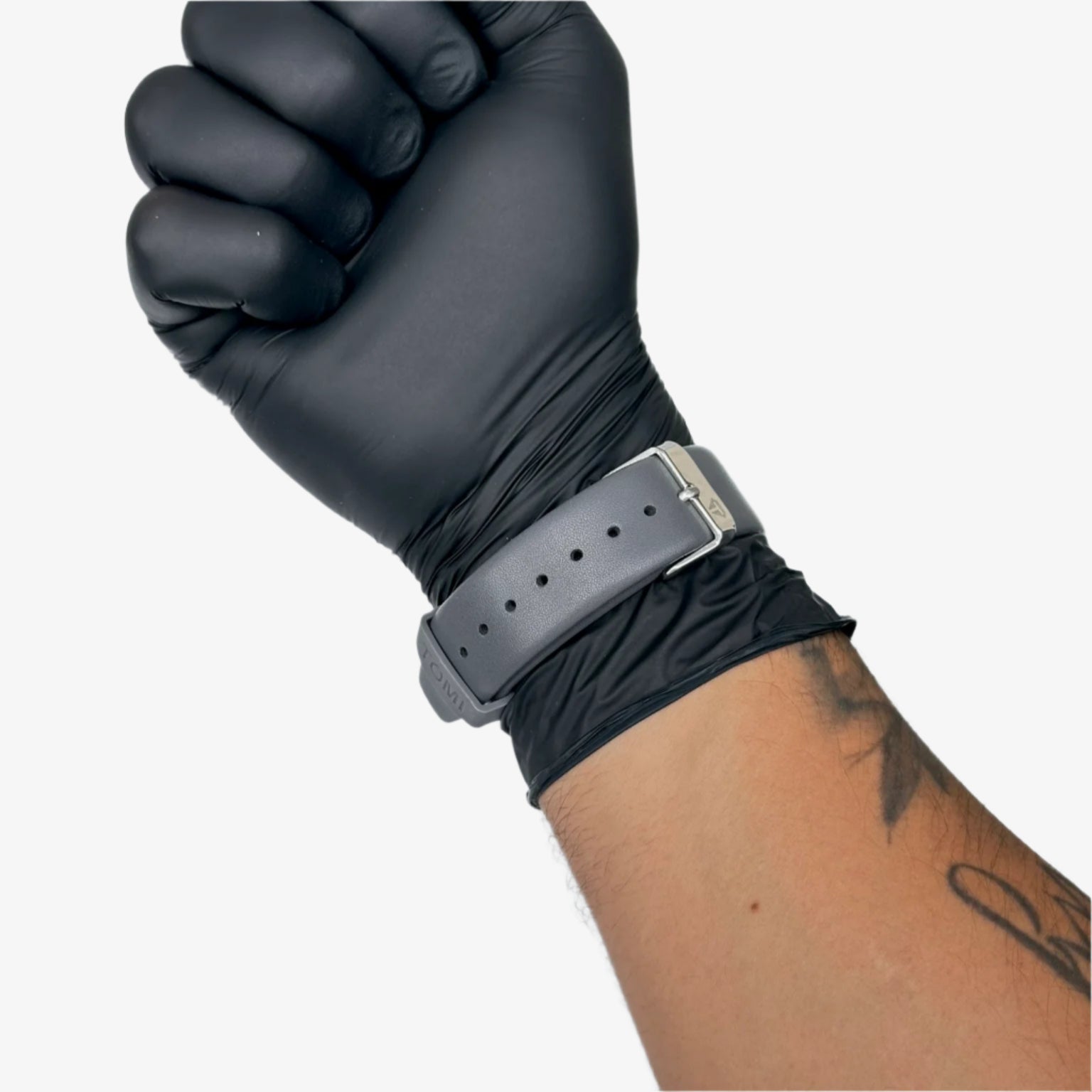 Black glove on a wrist with a gray belt against a gray background