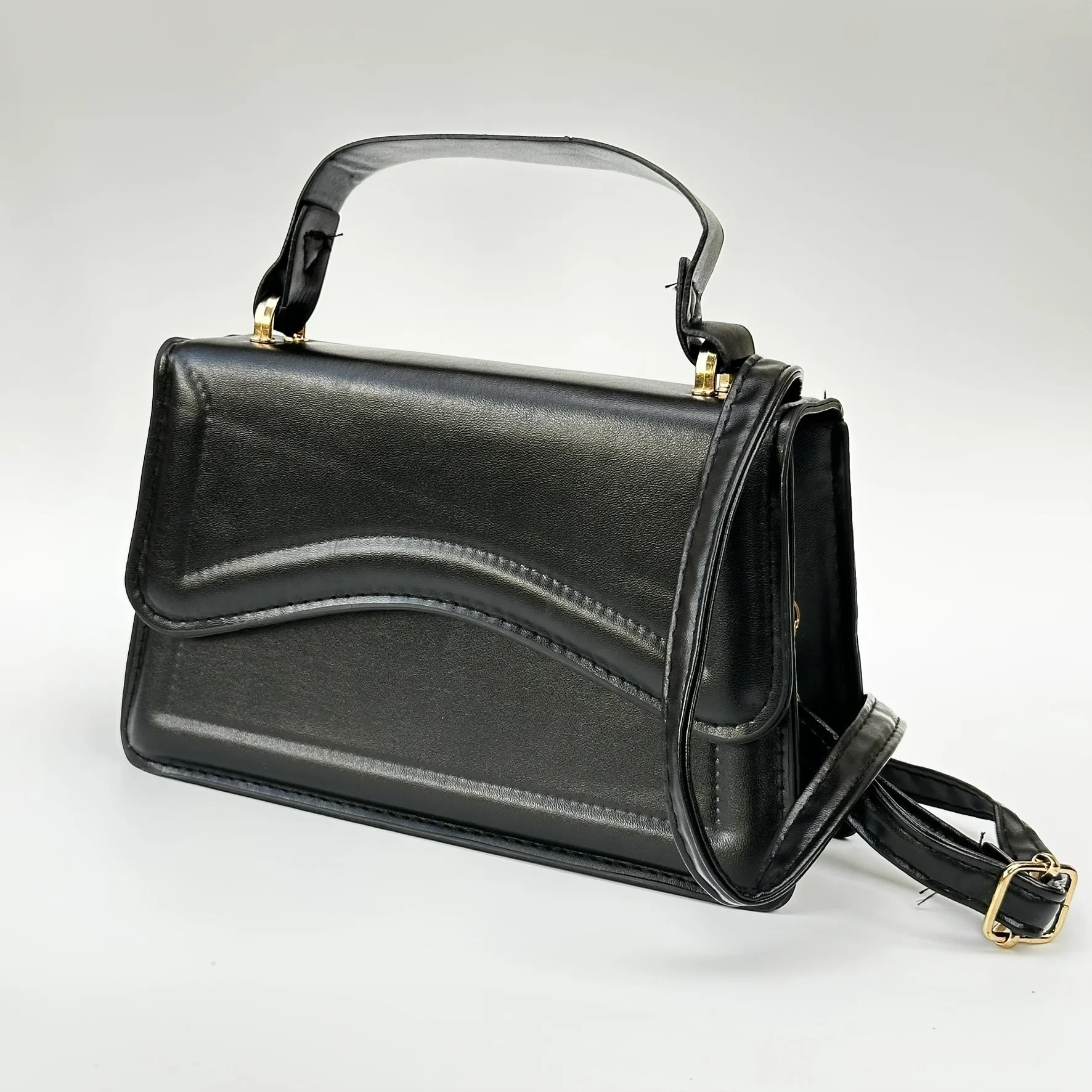 Black handbag with gold accents on a light gray background