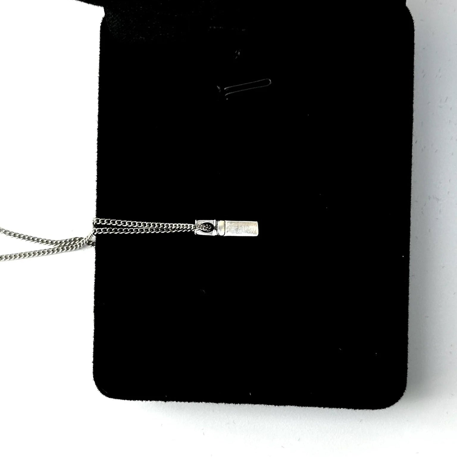 Black pouch with a silver cross on a white background
