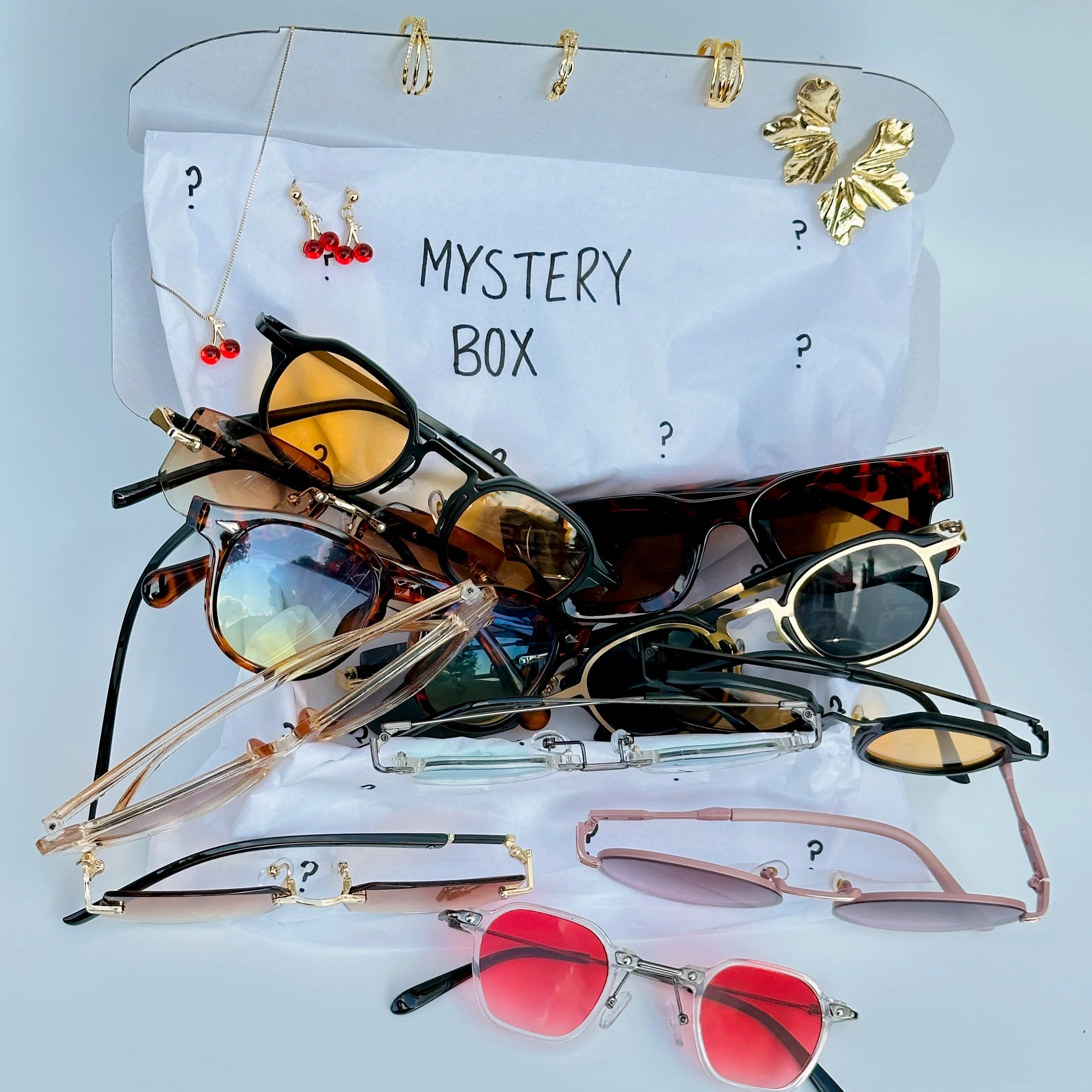 Collection of sunglasses on a clear stand with 'Mystery Box' label