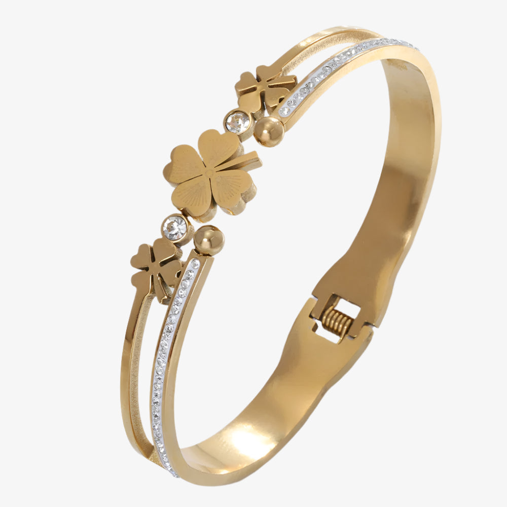 Gold bracelet with clover designs and small diamonds on a white background