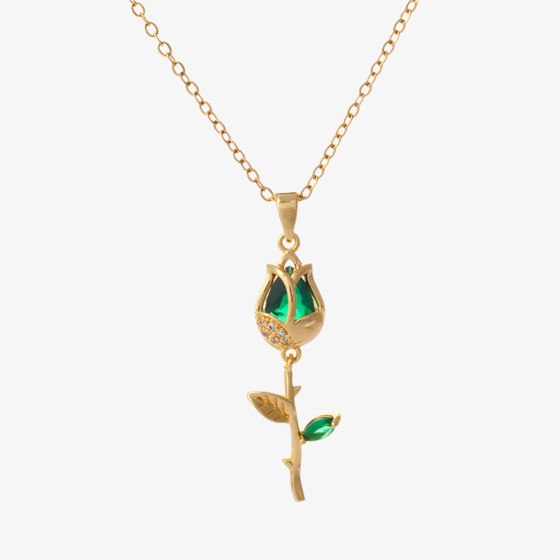 Gold necklace with a green gemstone pendant on a white background