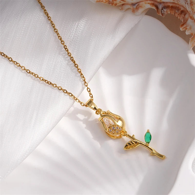 Gold necklace with a green gemstone pendant on a white fabric background