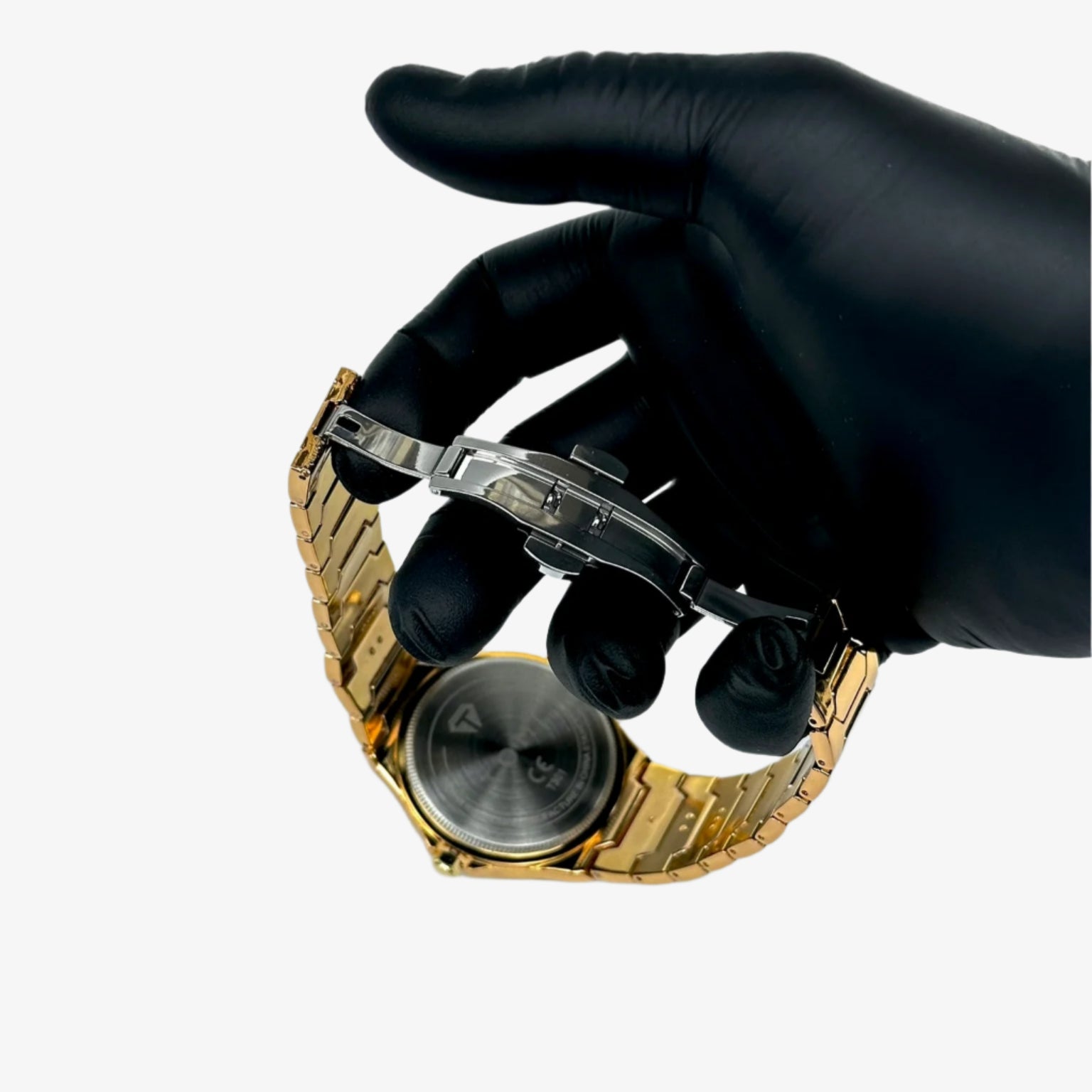 Gold watch being examined with a magnifying glass by a gloved hand on a white background