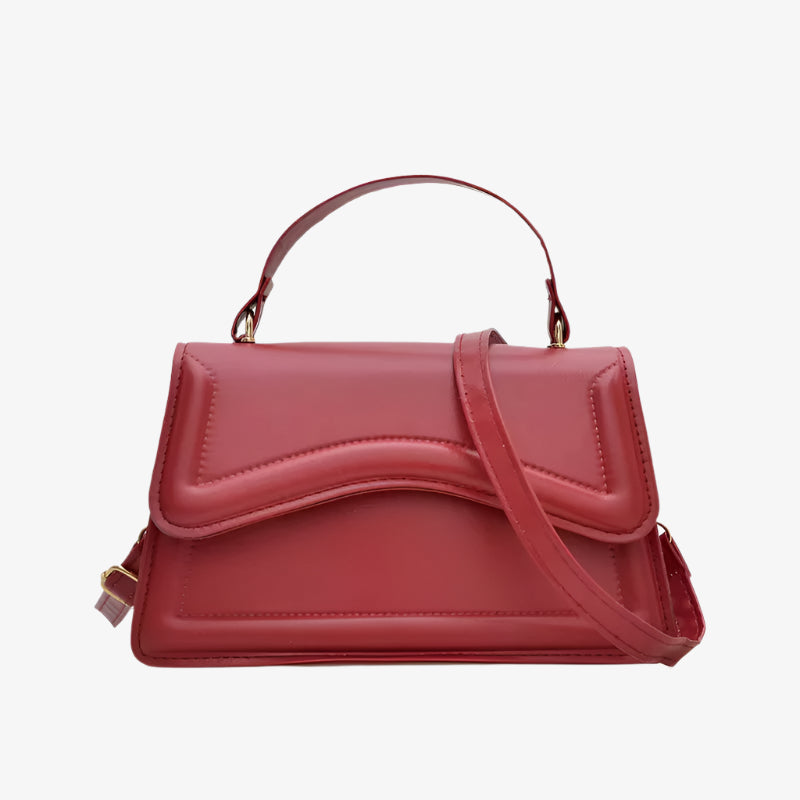 Red handbag with a strap on a white background