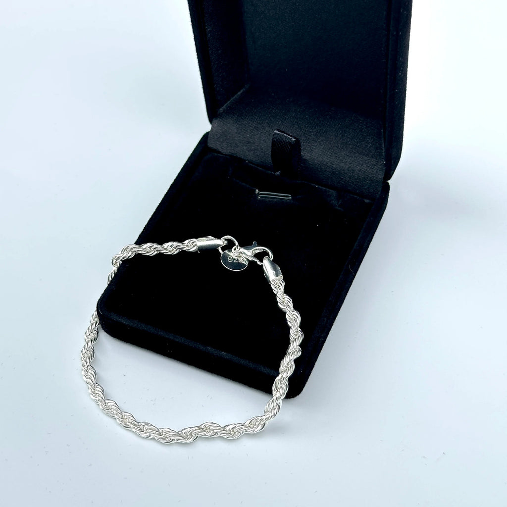 Silver bracelet on a black jewelry box with a white background