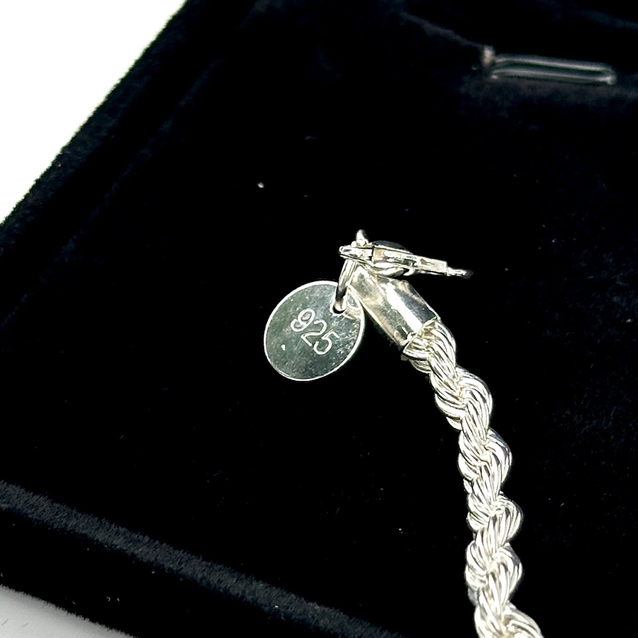 Silver bracelet with a clear gemstone on a black velvet background
