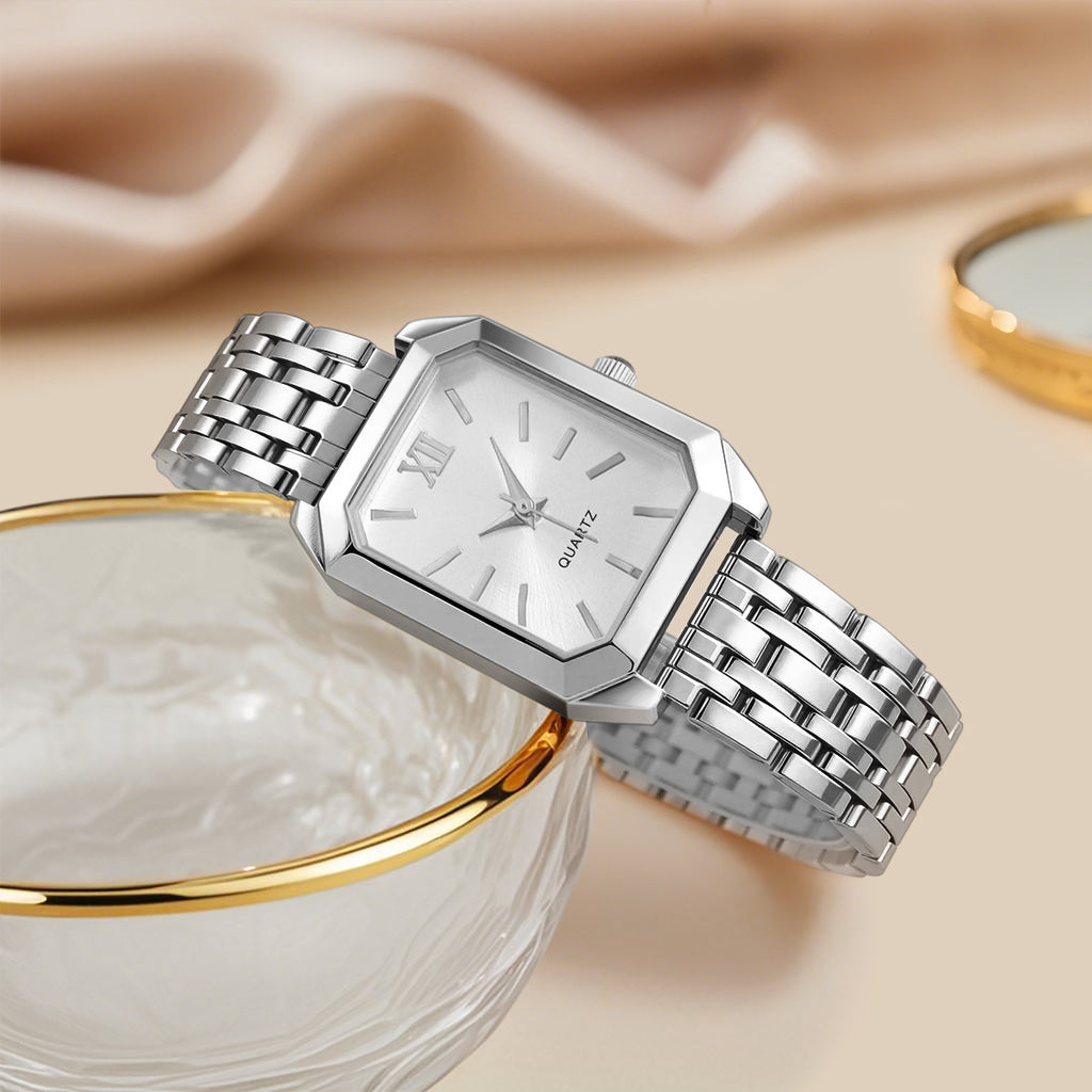 Silver watch with a metal band on a beige fabric background