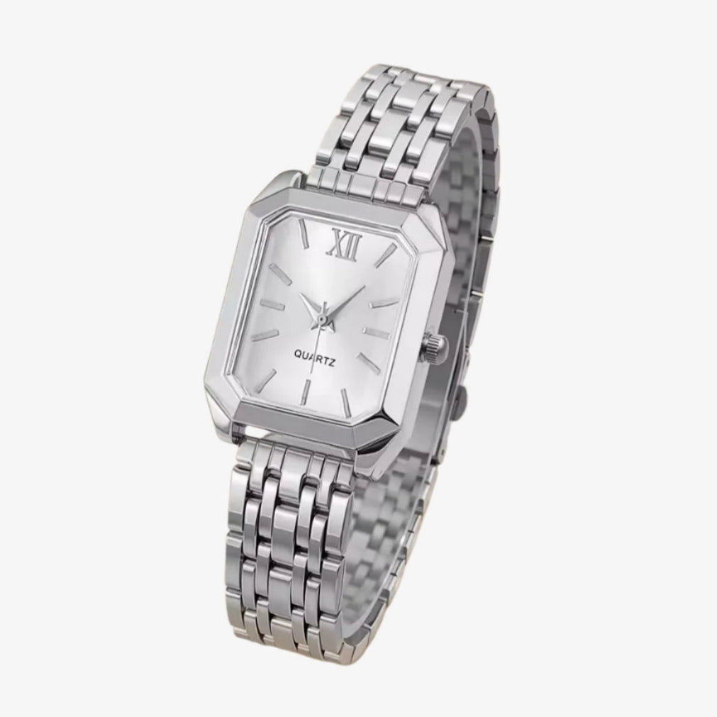 Silver wristwatch with a white face on a light gray background