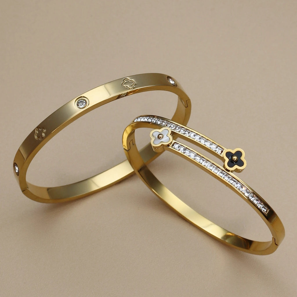 Two gold bracelets with diamond accents on a beige background