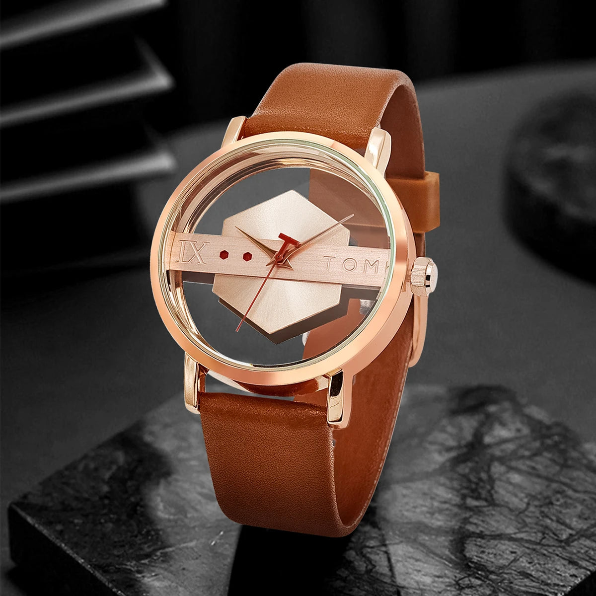 Watch with brown leather strap and rose gold case on a dark surface